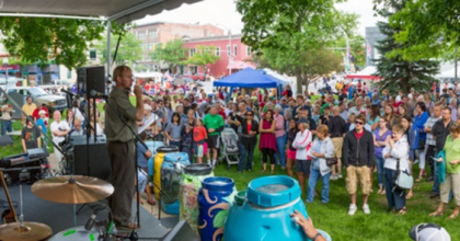 people gathered at an outdoor event for arbor day with a stage. 
