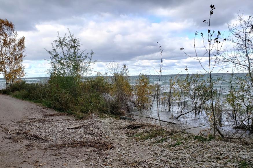 Erosion of campground gravel and dirt road into lake shoreline