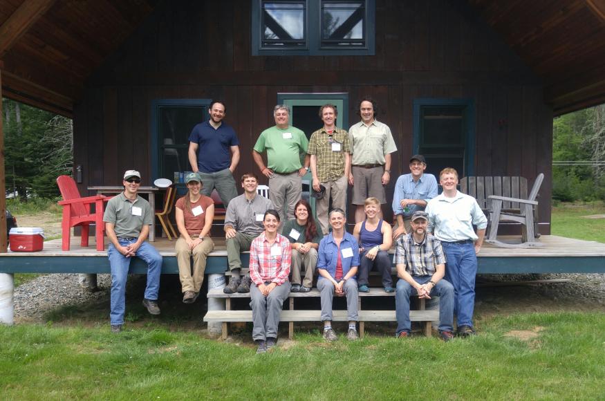 Fourteen scientists and managers sit on a porch at the Second College Grant